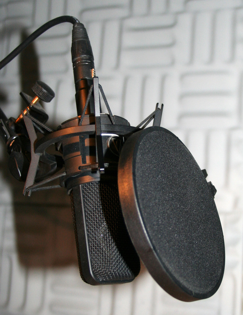 Studio condenser microphone with pop filter in a recording setup